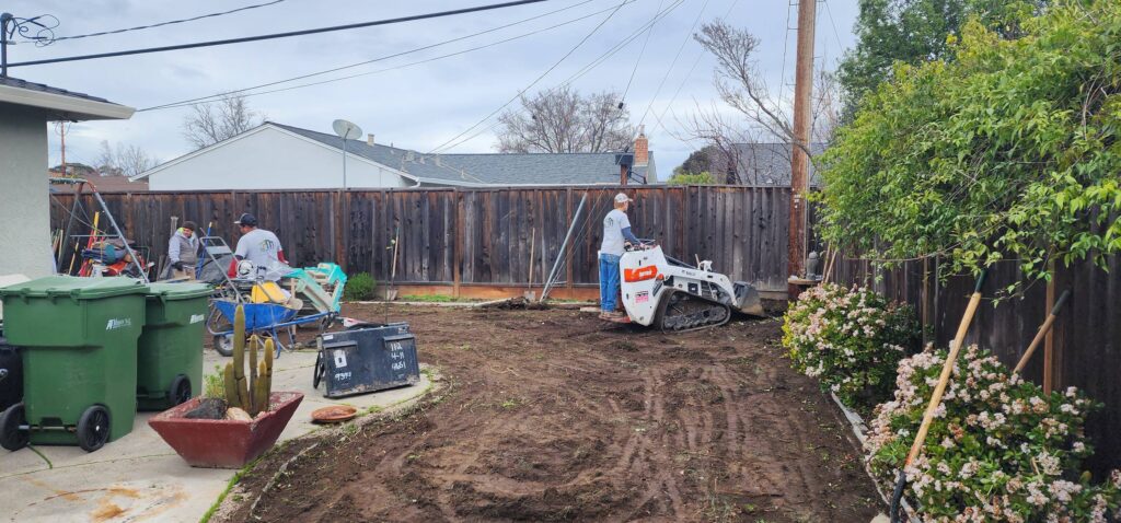 Bobcat services grading and leveling backyard in San Jose home